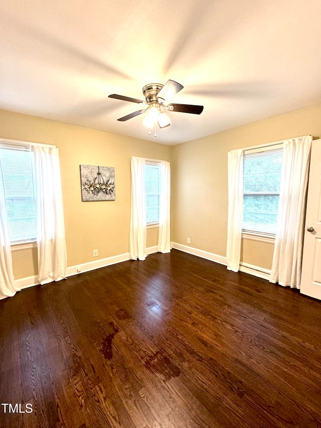 spare room featuring ceiling fan, plenty of natural light, and dark hardwood / wood-style floors