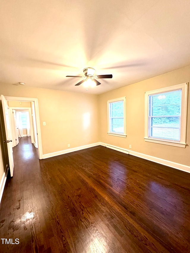 unfurnished room featuring dark hardwood / wood-style flooring, ceiling fan, and baseboard heating