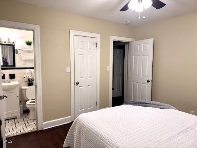 bedroom featuring ensuite bathroom, sink, ceiling fan, and dark hardwood / wood-style flooring