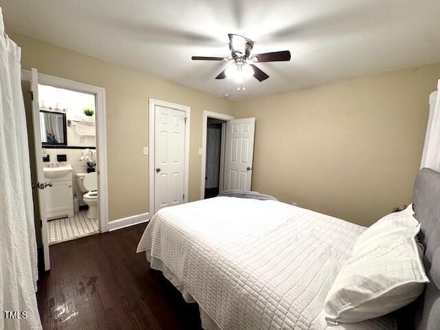 bedroom featuring ceiling fan, dark hardwood / wood-style floors, and ensuite bath