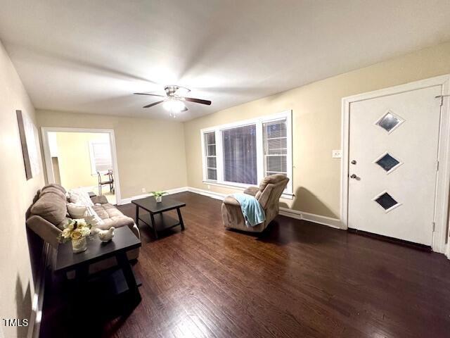 living room with ceiling fan and dark hardwood / wood-style flooring