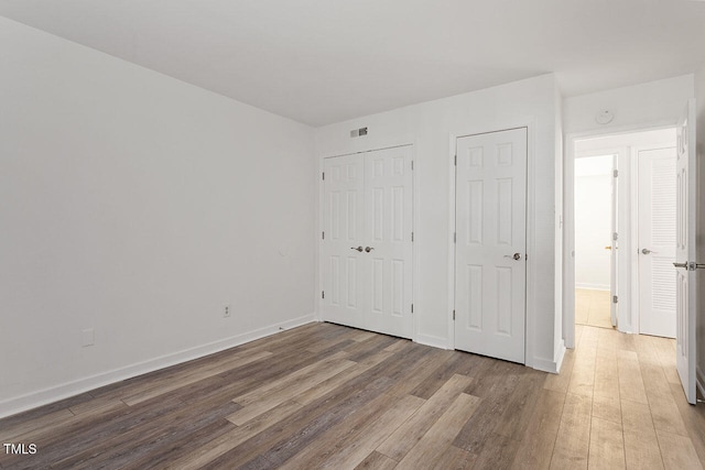 unfurnished bedroom with hardwood / wood-style floors