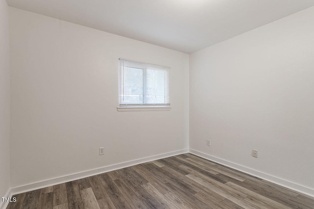 empty room with dark hardwood / wood-style flooring