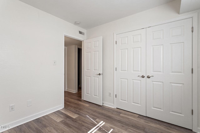 unfurnished bedroom featuring a closet and hardwood / wood-style floors