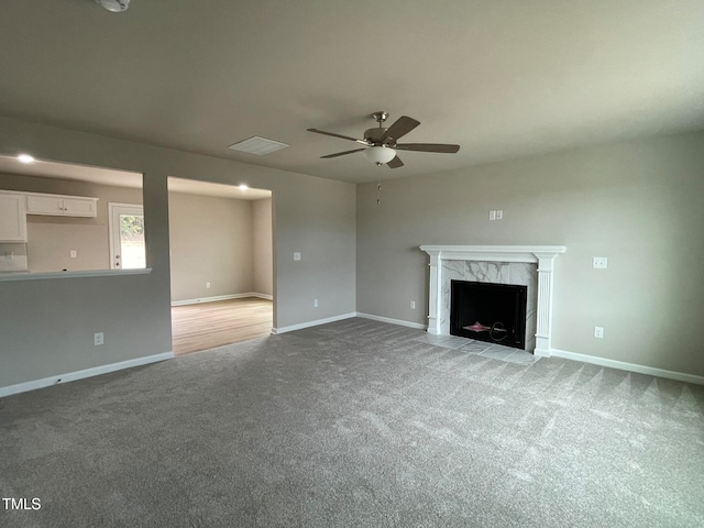 unfurnished living room with carpet flooring, a fireplace, and ceiling fan