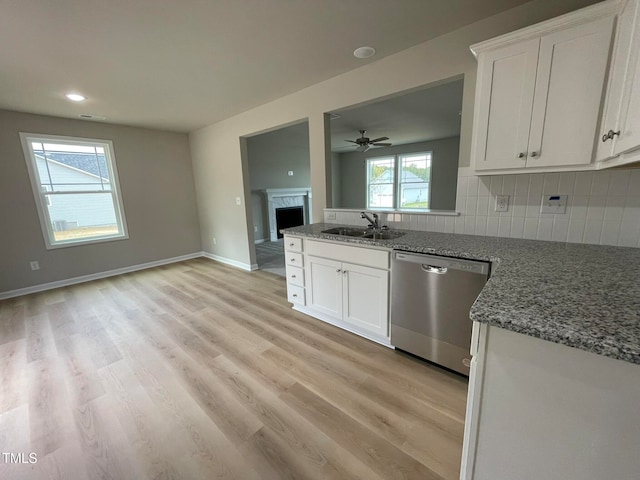 kitchen featuring stainless steel dishwasher, sink, white cabinetry, and light wood-type flooring