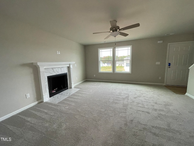 unfurnished living room with light carpet, a premium fireplace, and ceiling fan