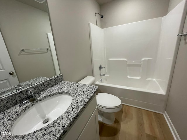 full bathroom featuring  shower combination, vanity, hardwood / wood-style flooring, and toilet