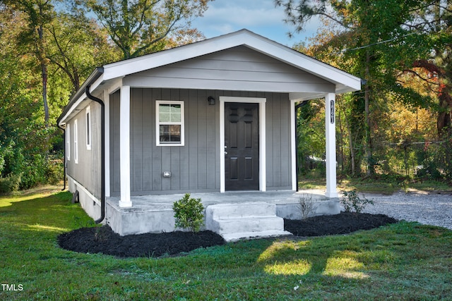 view of front of house featuring covered porch and a front lawn