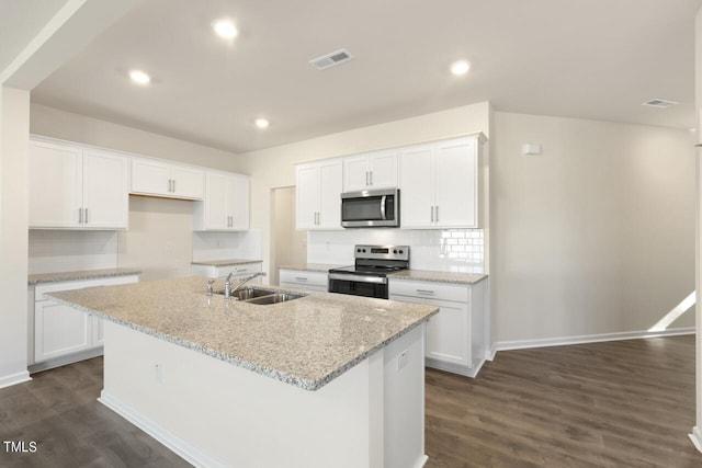 kitchen featuring white cabinets, stainless steel appliances, sink, and an island with sink