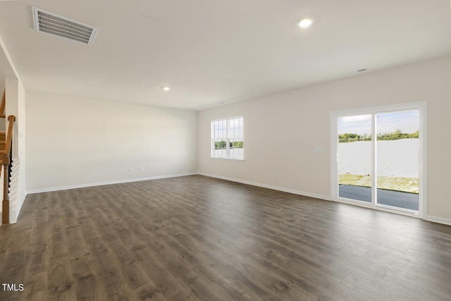 unfurnished living room featuring dark hardwood / wood-style flooring and plenty of natural light