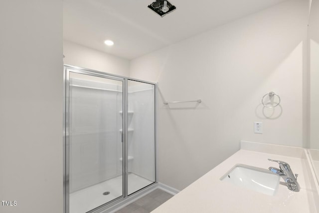 bathroom featuring vanity, walk in shower, and wood-type flooring