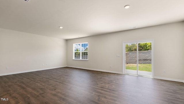 unfurnished room featuring dark wood-style floors, baseboards, and a wealth of natural light