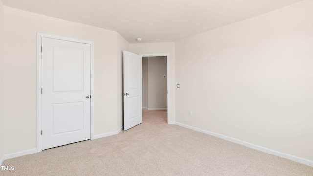 unfurnished bedroom with baseboards and light carpet