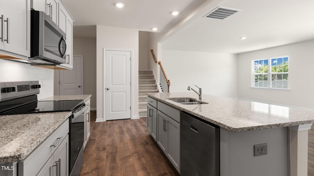 kitchen with dark wood-style floors, visible vents, a sink, appliances with stainless steel finishes, and backsplash