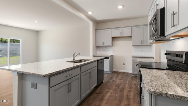 kitchen with dark wood-type flooring, gray cabinetry, a sink, tasteful backsplash, and appliances with stainless steel finishes