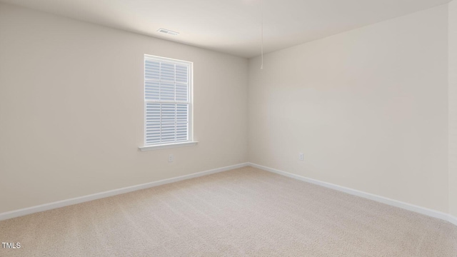 carpeted empty room with visible vents and baseboards