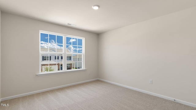 empty room with visible vents, baseboards, and carpet flooring