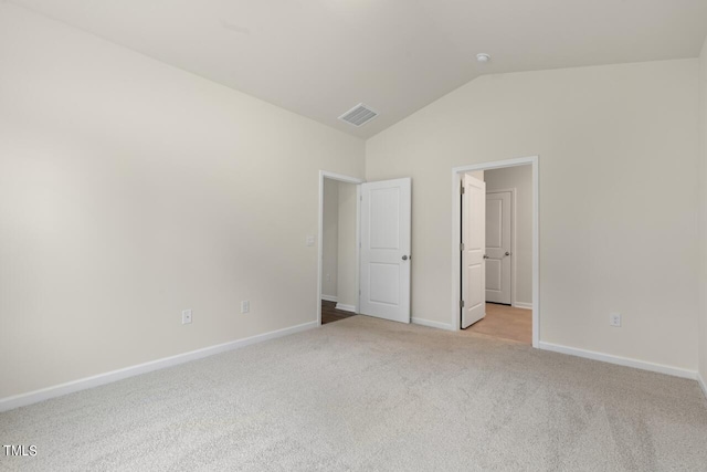 unfurnished bedroom with vaulted ceiling and light colored carpet