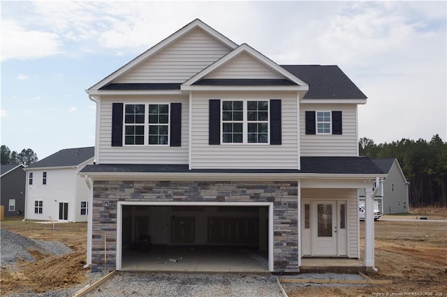 view of front of home featuring an attached garage, stone siding, driveway, and a shingled roof