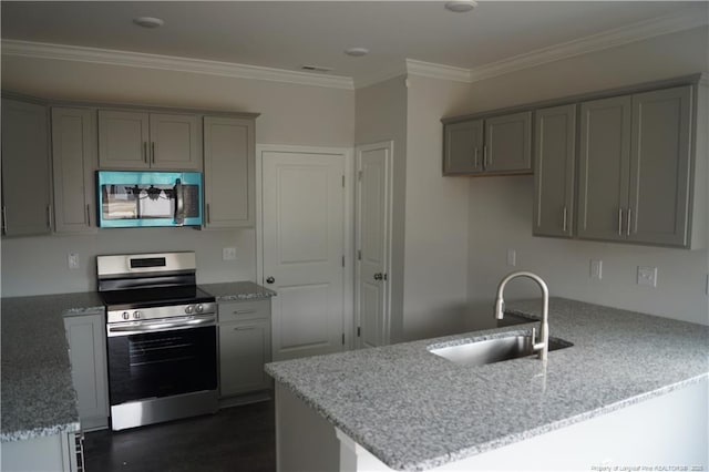 kitchen featuring light stone counters, appliances with stainless steel finishes, gray cabinets, and a sink