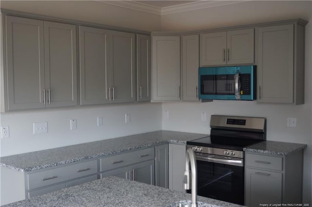 kitchen featuring stainless steel appliances, ornamental molding, gray cabinetry, and light stone countertops