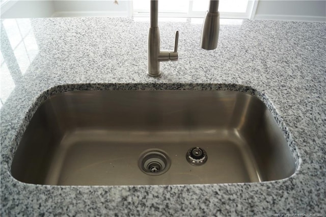 details with a sink and light stone countertops