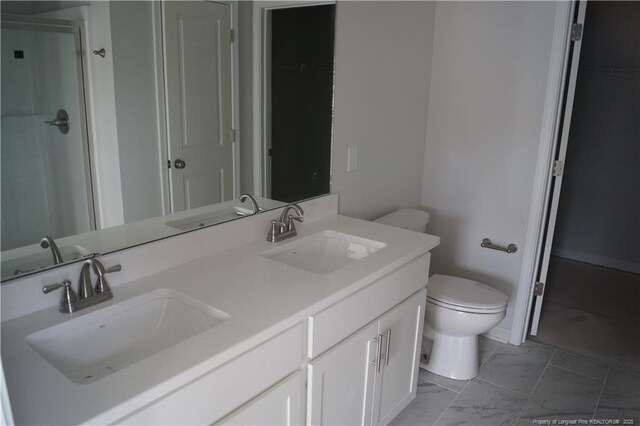 bathroom with toilet, marble finish floor, and a sink