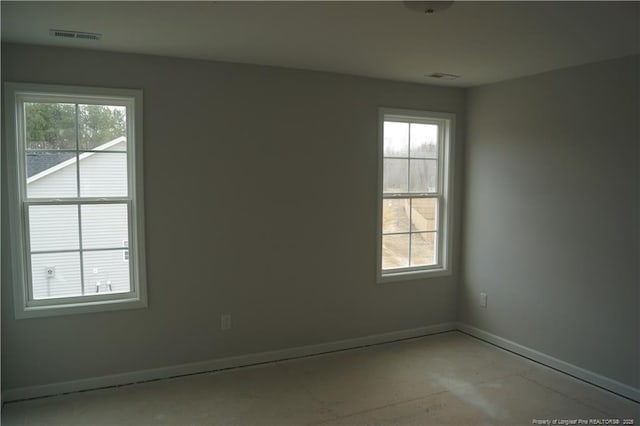 spare room with plenty of natural light, baseboards, and visible vents