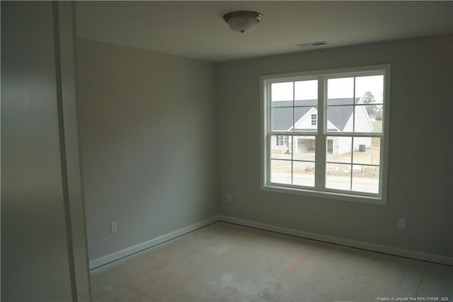 spare room with a wealth of natural light, visible vents, and baseboards