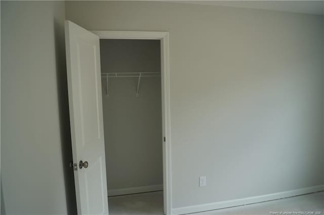 unfurnished bedroom with a closet and baseboards