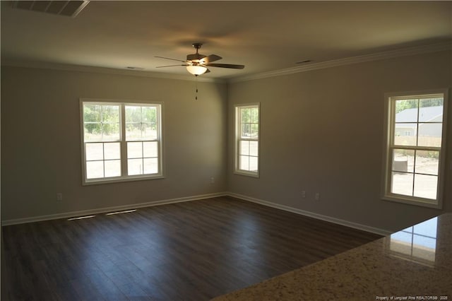 unfurnished room with dark wood-type flooring, visible vents, and a wealth of natural light