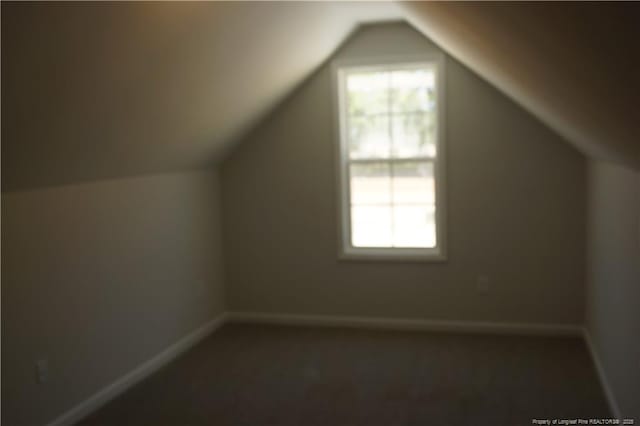 additional living space with carpet floors, baseboards, and vaulted ceiling