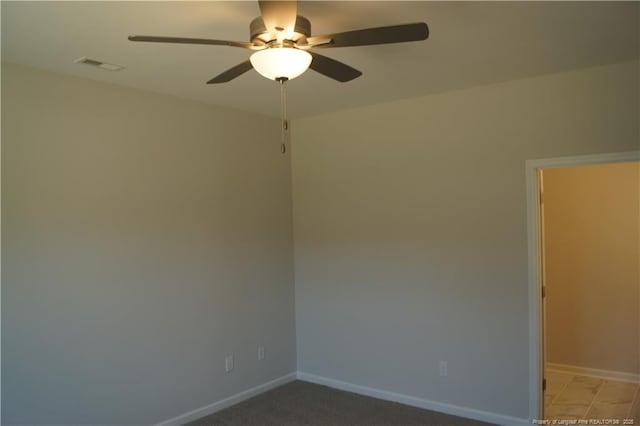 unfurnished room with ceiling fan, visible vents, and baseboards
