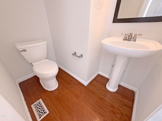 bathroom with hardwood / wood-style flooring and toilet