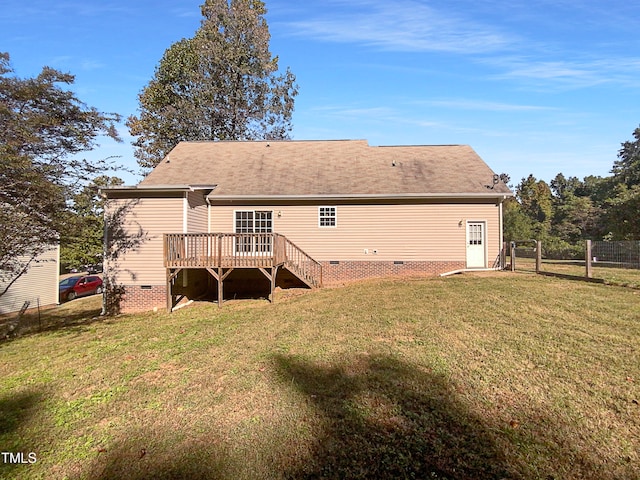 rear view of property featuring a wooden deck and a yard