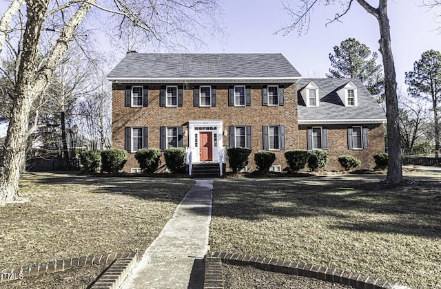 colonial inspired home featuring a front yard