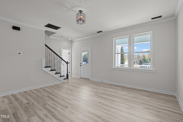 foyer with crown molding, light hardwood / wood-style flooring, and an inviting chandelier