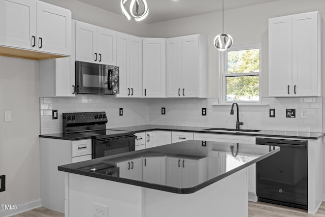 kitchen featuring sink, black appliances, and white cabinetry