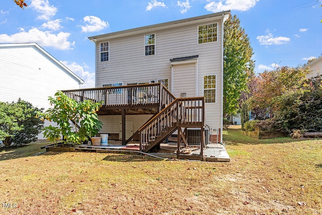 rear view of property with a wooden deck and a lawn