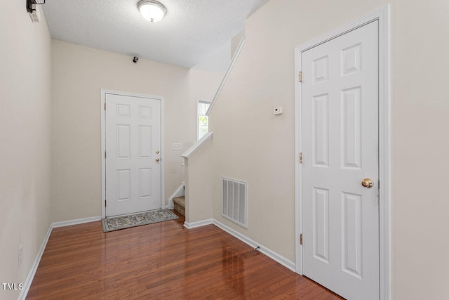 foyer featuring hardwood / wood-style flooring and a textured ceiling