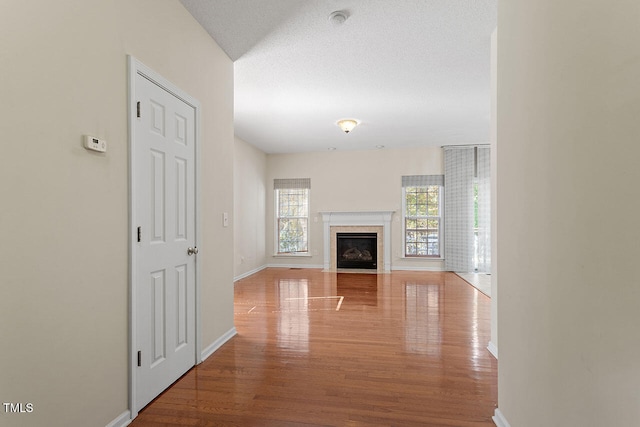 unfurnished living room with a textured ceiling and hardwood / wood-style flooring