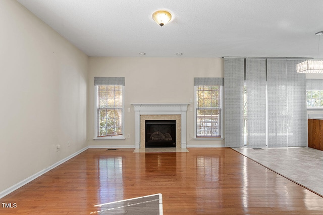 unfurnished living room with wood-type flooring and a textured ceiling