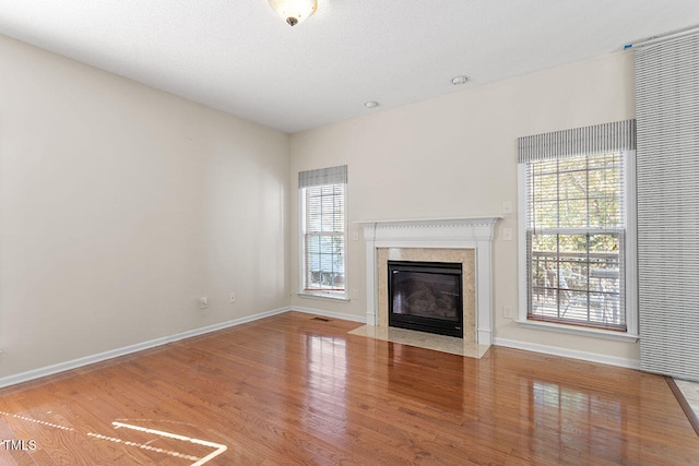 unfurnished living room featuring hardwood / wood-style floors, a textured ceiling, and plenty of natural light