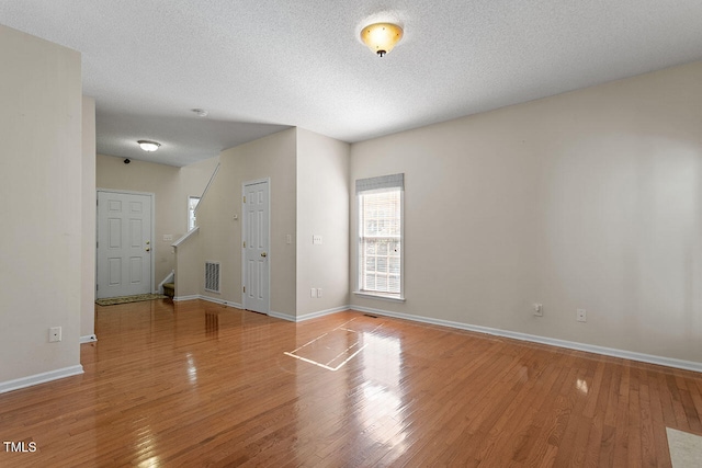 spare room with hardwood / wood-style floors and a textured ceiling