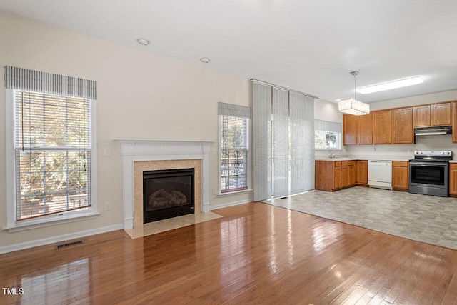 kitchen featuring a healthy amount of sunlight, hanging light fixtures, dishwasher, and stainless steel electric range oven