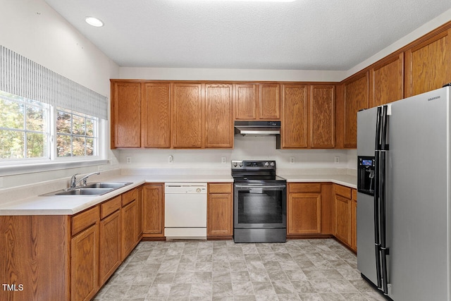 kitchen with stainless steel appliances, a textured ceiling, and sink