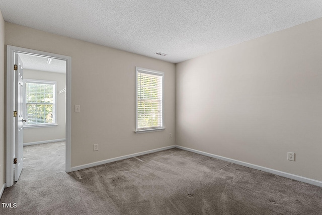 unfurnished room with light carpet and a textured ceiling