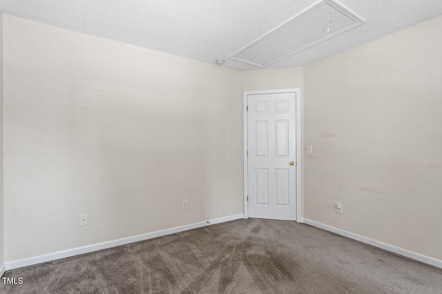 carpeted empty room featuring a textured ceiling