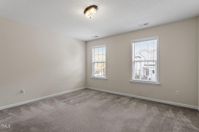 carpeted empty room with a textured ceiling